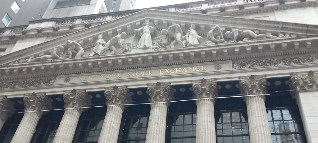 The facade of the New York Stock Exchange in New York's financial district, with its gold lettering and Corinthian columns.