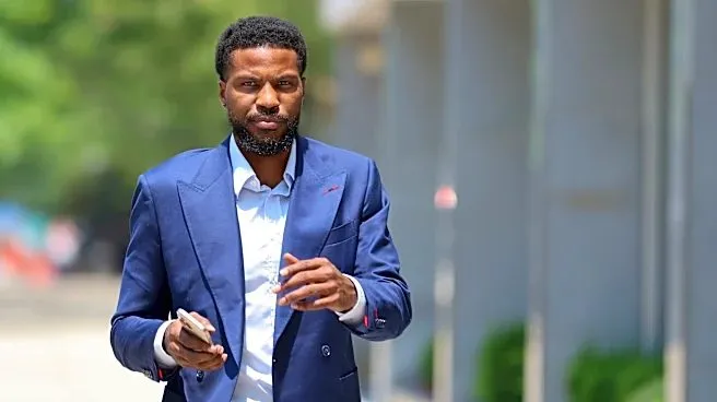 Malik Beasley in a blue suit outside a building