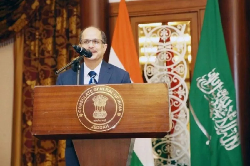 An official speaks at the Consulate General of India in Jeddah, flanked by Indian and Saudi flags