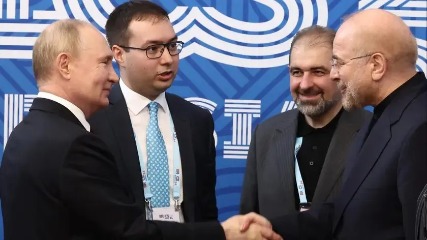 Iranian parliament speaker Mohammad Bagher Ghalibaf shakes hands with Russian President Vladimir Putin at a BRICS event