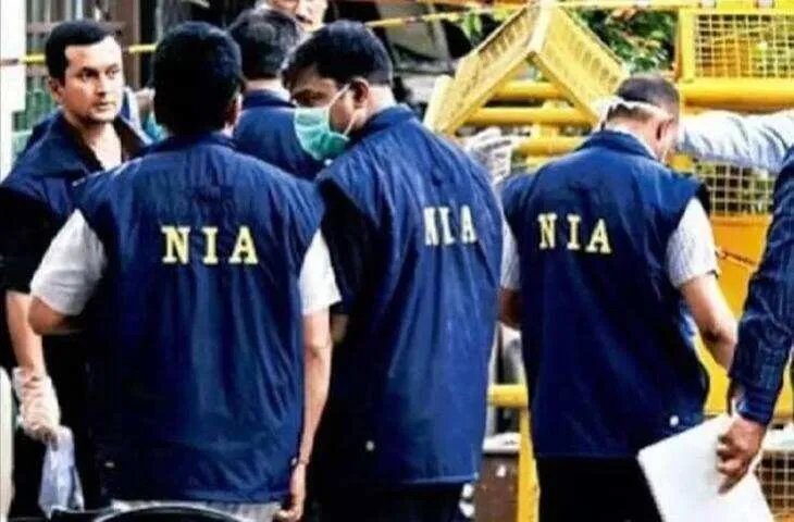 Officers of India's National Investigation Agency (NIA) wearing NIA vests at a crime scene