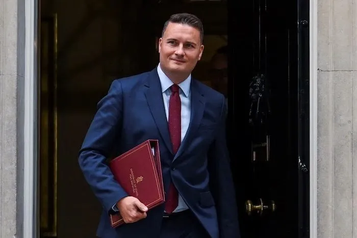 Wes Streeting carrying a red ministerial folder outside a Downing Street doorway