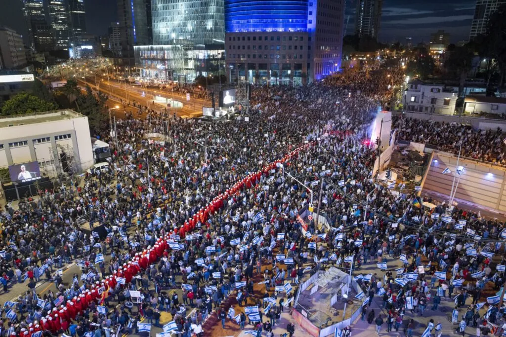 Thousands of protesters with Israeli flags fill a Tel Aviv street at night