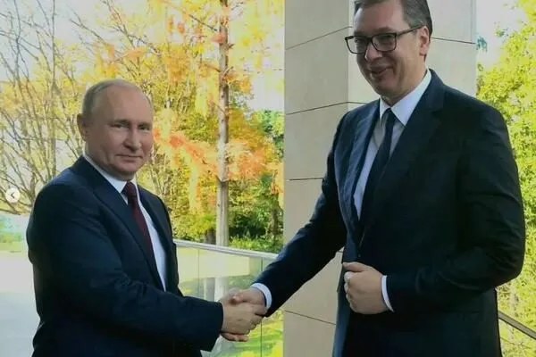 Vladimir Putin shaking hands with Aleksandar Vucic