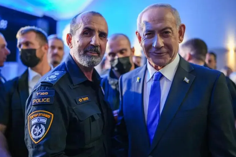 Benjamin Netanyahu standing beside an Israeli police officer