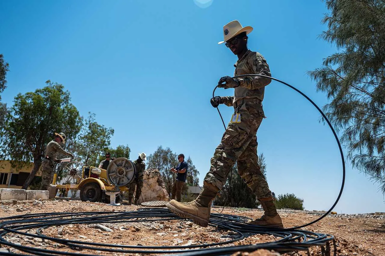 A fiber-optic installation crew feeding cable into the ground — the kind of fieldwork that brings broadband to rural homes.