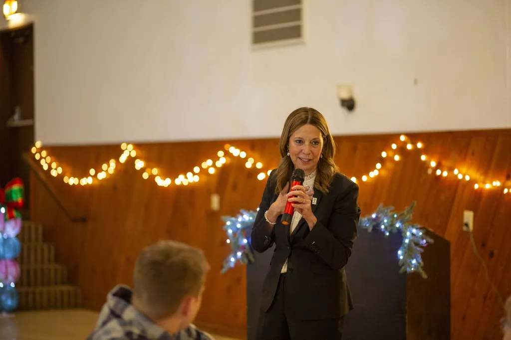 Amy Acton speaking into a microphone at a public event in 2025