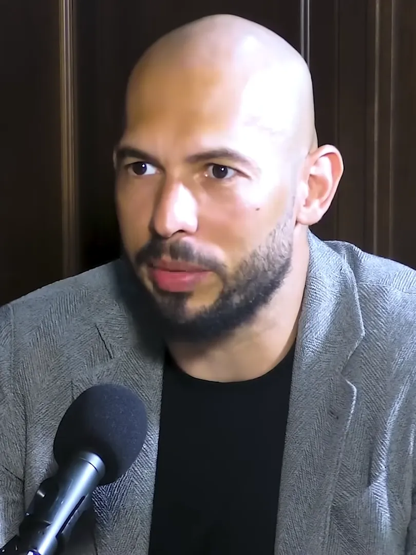 Andrew Tate speaking into a microphone during a 2023 podcast appearance