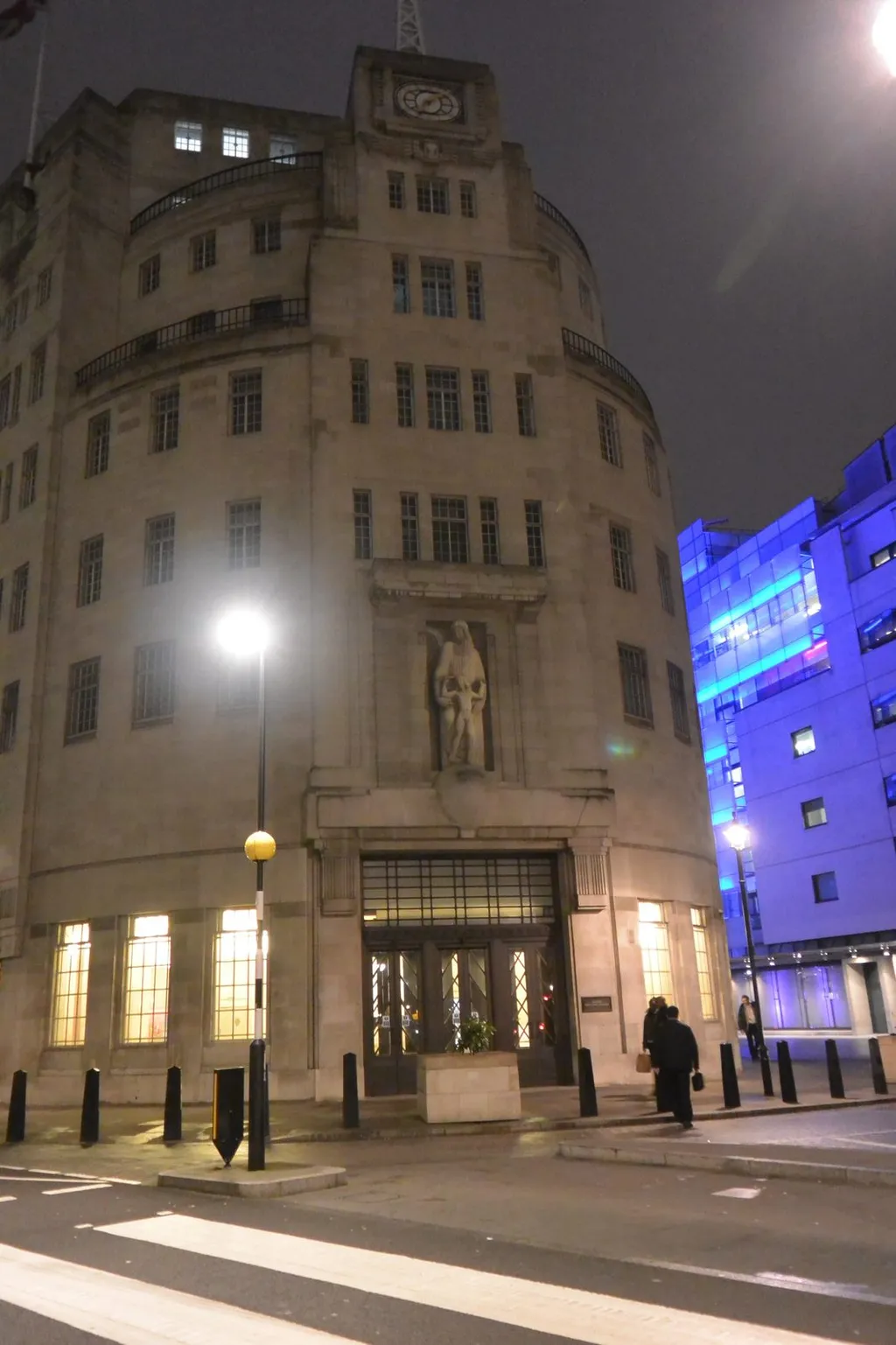BBC Broadcasting House on Portland Place, London, photographed at night with its Art Deco facade and the Prospero and Ariel sculpture above the entrance.