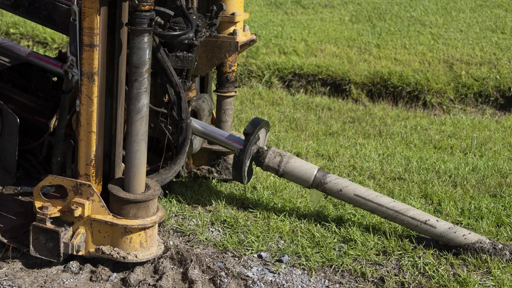 A directional drilling rig inserts underground conduit for fibre-optic cable in a rural field in Berkeley County, South Carolina, during a USDA ReConnect broadband project.