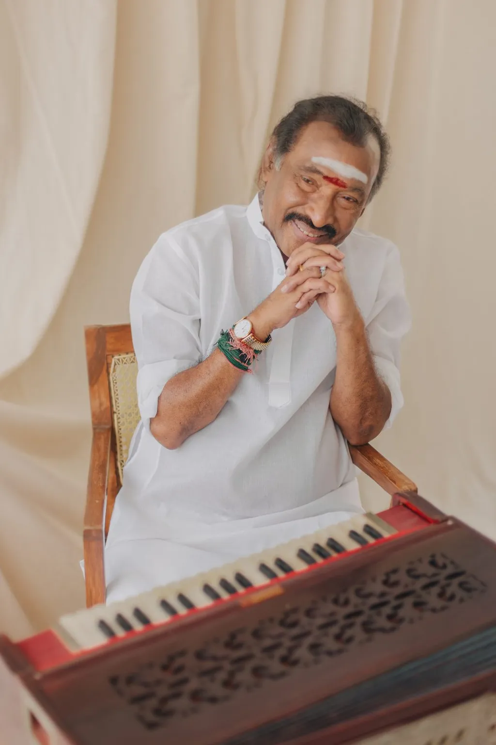 Music composer Deva, 'Thenisai Thendral', garlanded and speaking at a podium at an event in 2024