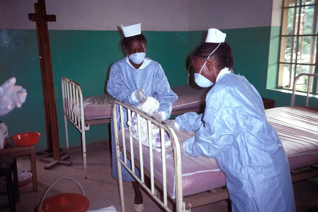 File photo of two nurses in protective equipment changing bedding in an Ebola isolation ward in Kikwit, then Zaire and now the Democratic Republic of Congo, in 1995.