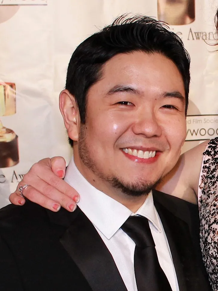 Eric Bauza smiling in a suit at the 41st Annie Awards in 2014