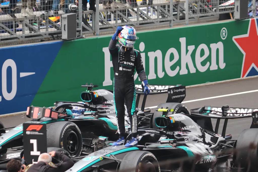 Mercedes driver Kimi Antonelli in race suit and helmet, celebrating on his Formula 1 car after the 2026 Chinese Grand Prix.