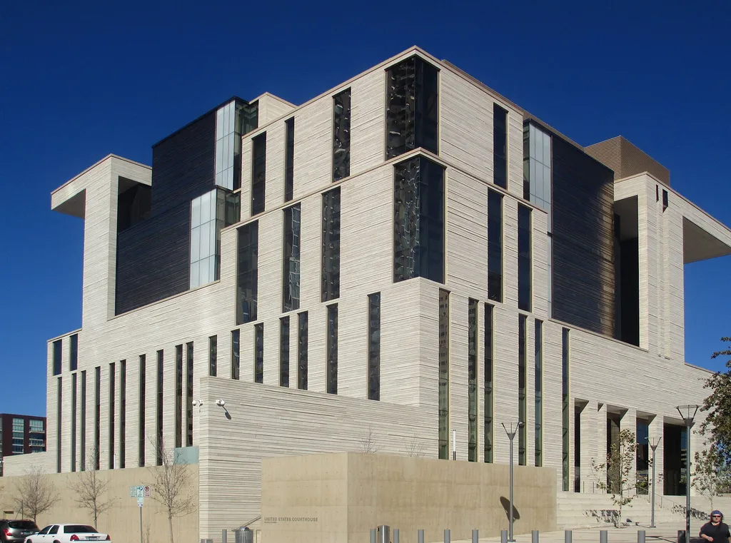The United States Courthouse in Austin, Texas, a modern limestone building under a clear blue sky.