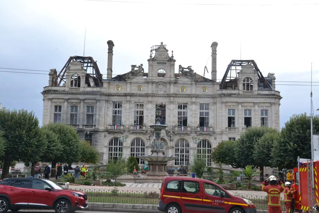 Firefighters outside the fire-gutted Limoges town hall (hôtel de ville), its roof structure collapsed and facade scorched, after the 17 October arson during cost-of-living protests.
