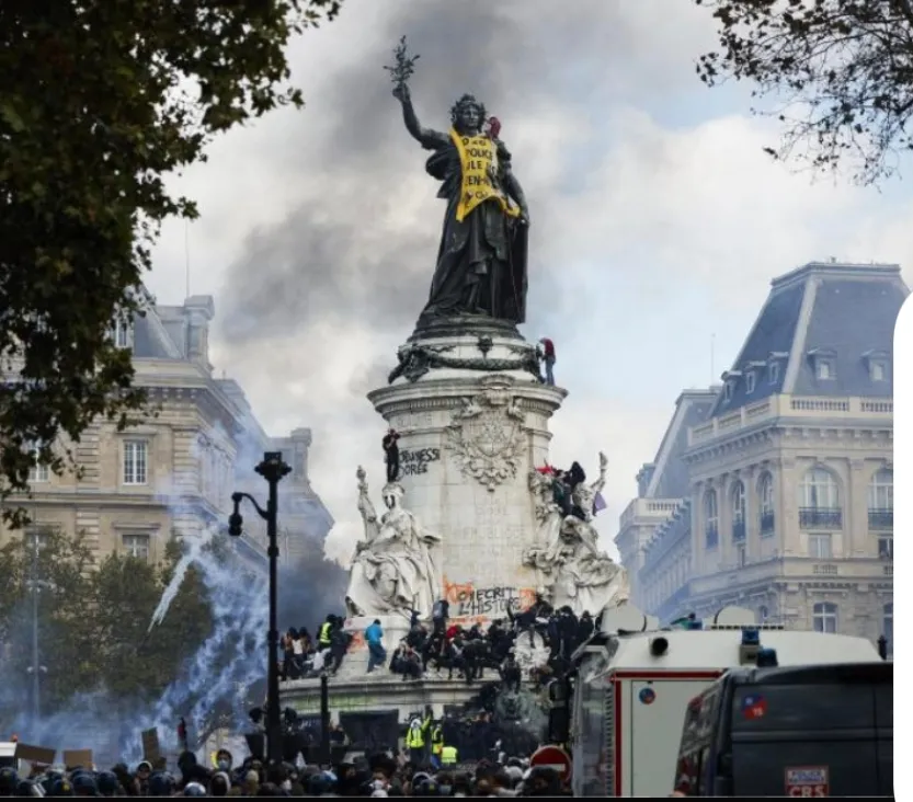 Protesters gather around the Marianne statue at Place de la République in Paris on 17 October 2026, with tear gas smoke drifting over the crowd during the demonstrations against the rising cost of living