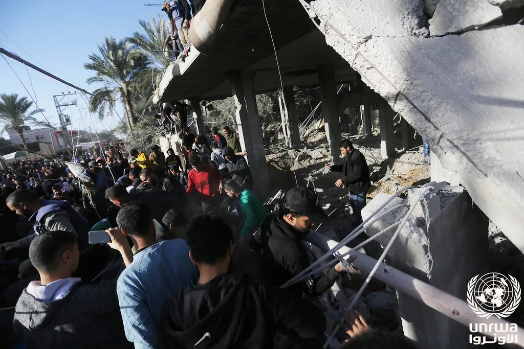 Palestinians carry out search and rescue around the rubble of a destroyed building in Deir el-Balah, Gaza Strip