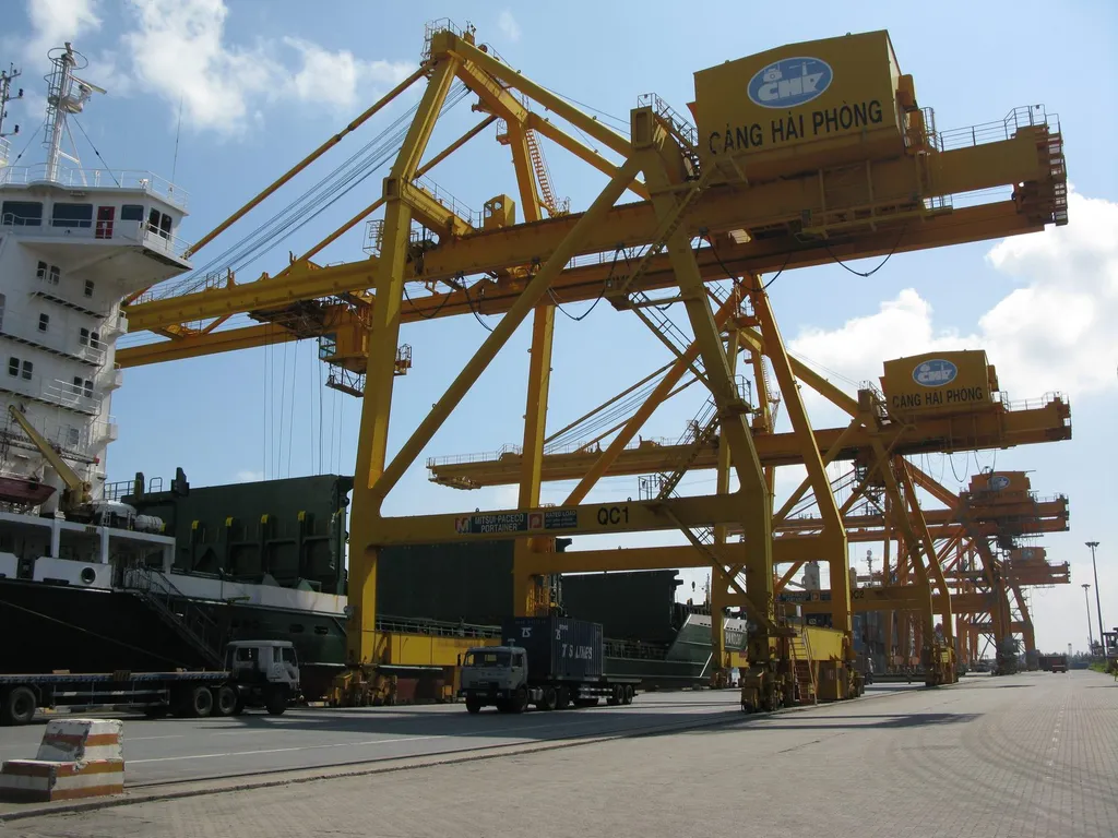 Container cranes at the Chua Ve terminal, Port of Hai Phong, Vietnam, with a container ship berthed alongside