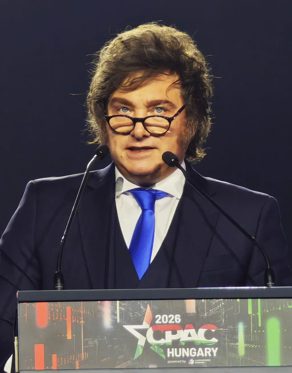 Argentine President Javier Milei speaking at a podium at CPAC Hungary in 2026