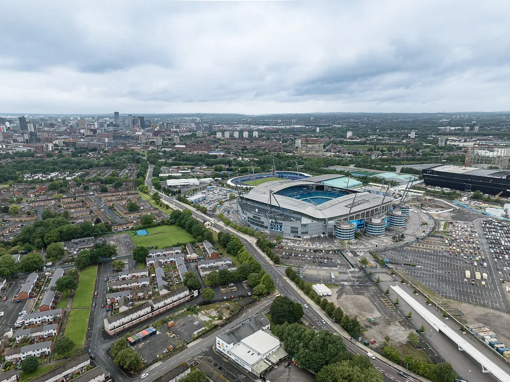 Aerial view of the Etihad Stadium in Manchester, home of Manchester City, under a cloudy sky