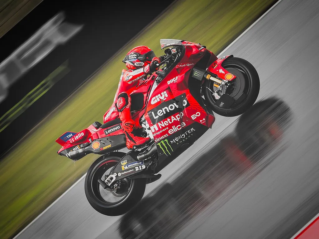 Marc Marquez lifting the front wheel of the red factory Ducati Lenovo MotoGP bike during the 2025 Czech Grand Prix at Brno.