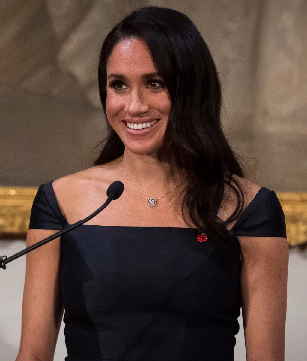 Meghan, Duchess of Sussex, smiling at a podium during a reception in Wellington, New Zealand, in 2018