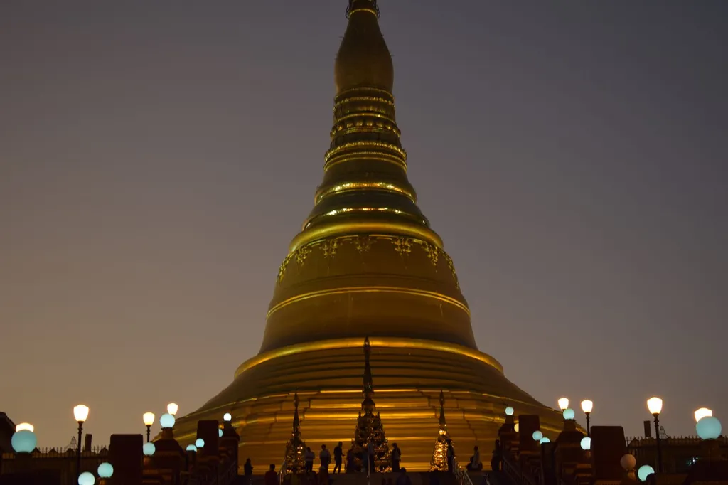 Night view of the golden Uppatasanti Pagoda in Naypyitaw, Myanmar, illuminated against a dark sky