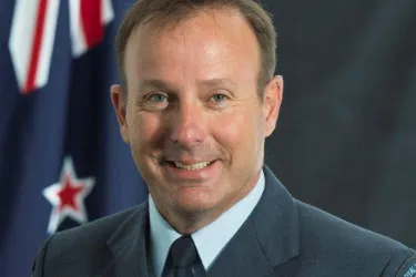 Portrait of Air Marshal Tony Davies in Royal New Zealand Air Force uniform in front of the New Zealand flag.