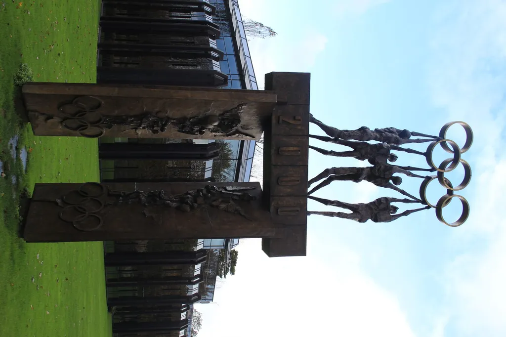 Olympic rings sculpture with athlete figures outside the IOC headquarters in Lausanne, Switzerland