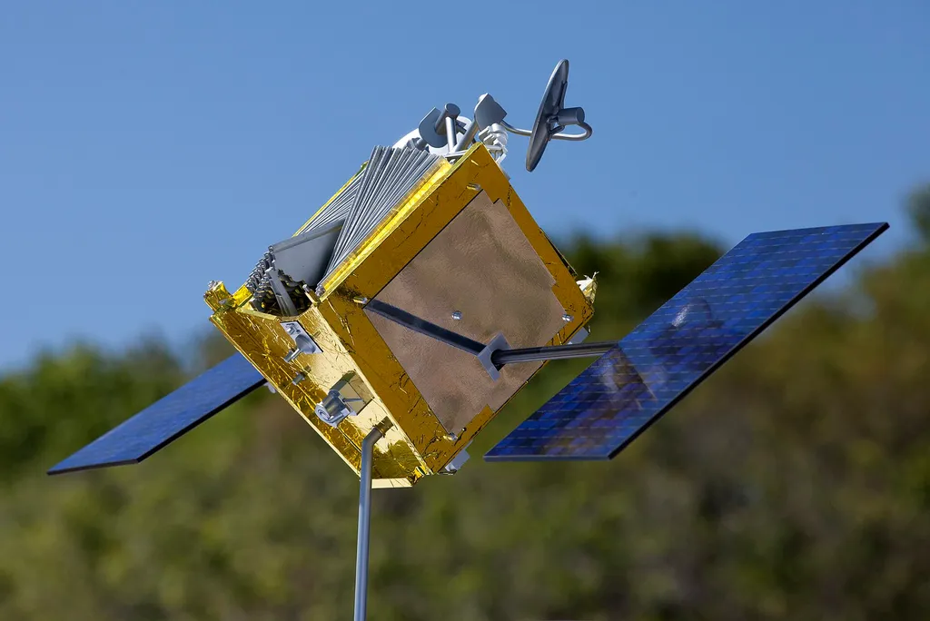 A full-size model of a OneWeb broadband satellite with gold foil body and blue solar panels, photographed by NASA.
