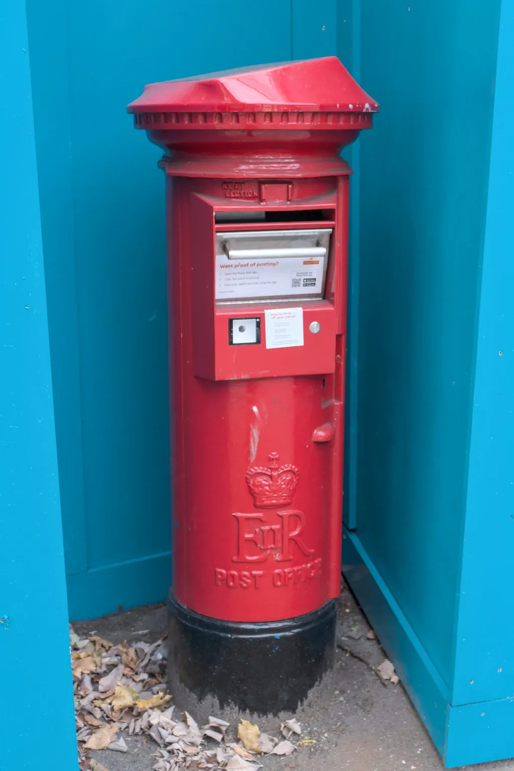 A red Royal Mail post box on a street in Nottingham