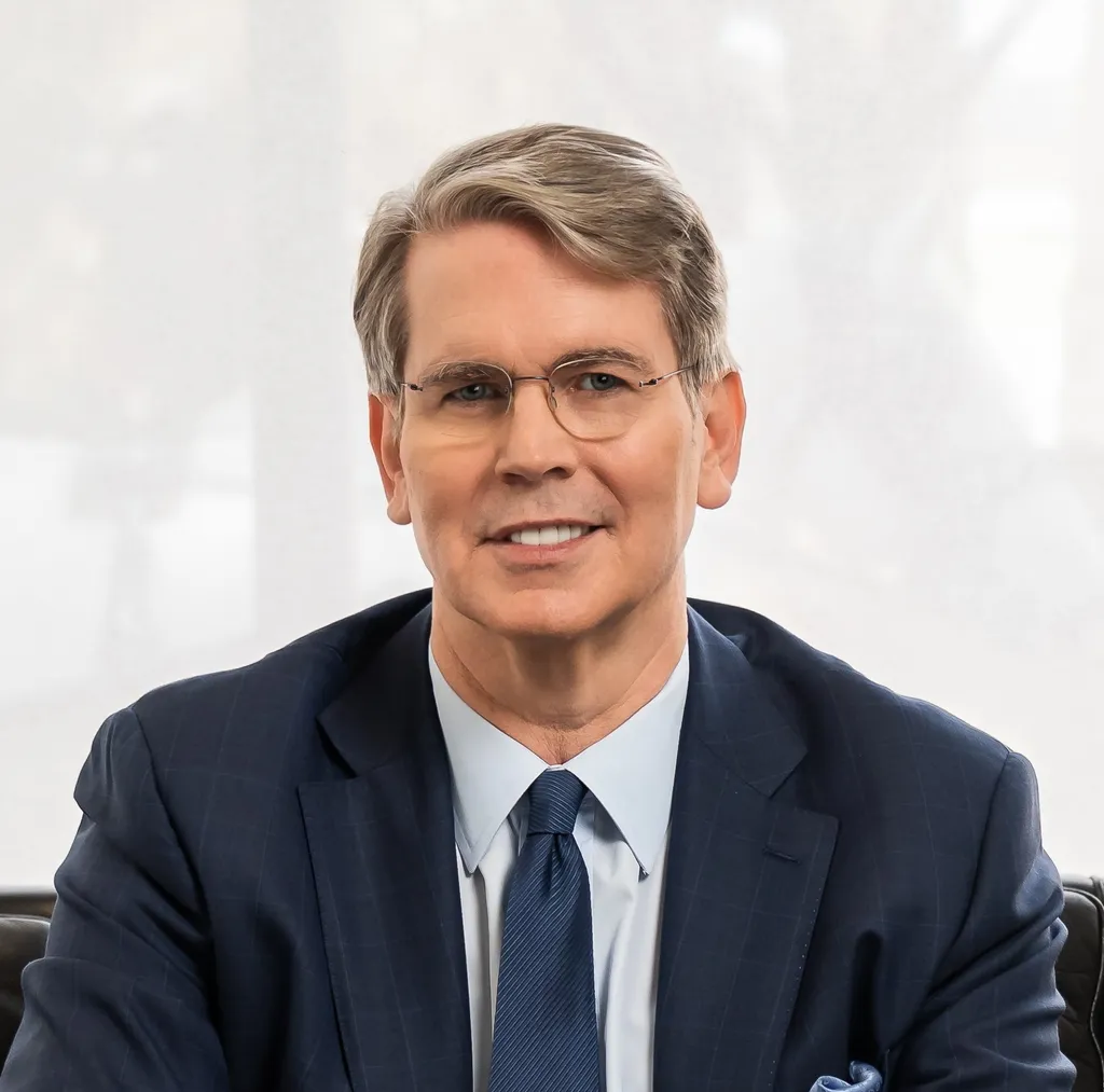 Official portrait of U.S. Treasury Secretary Scott Bessent in a dark suit and glasses.