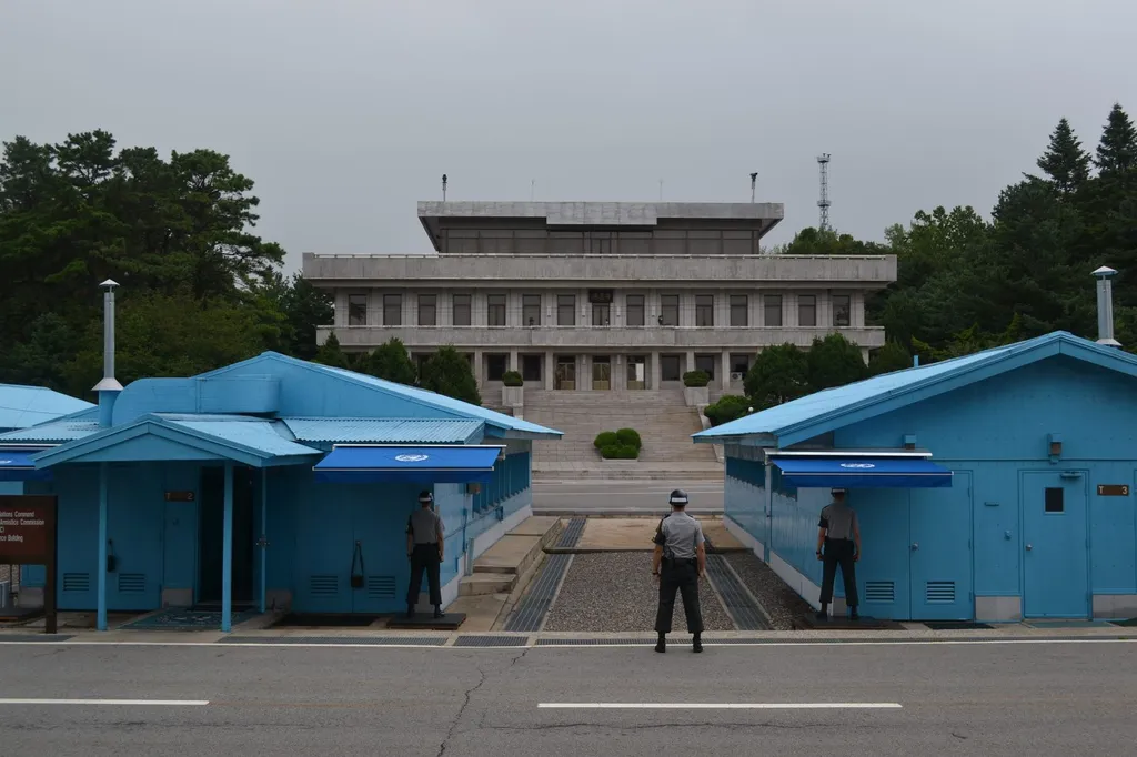 The blue negotiation huts of the Joint Security Area at Panmunjom in the Korean Demilitarized Zone, with South Korean guards standing watch