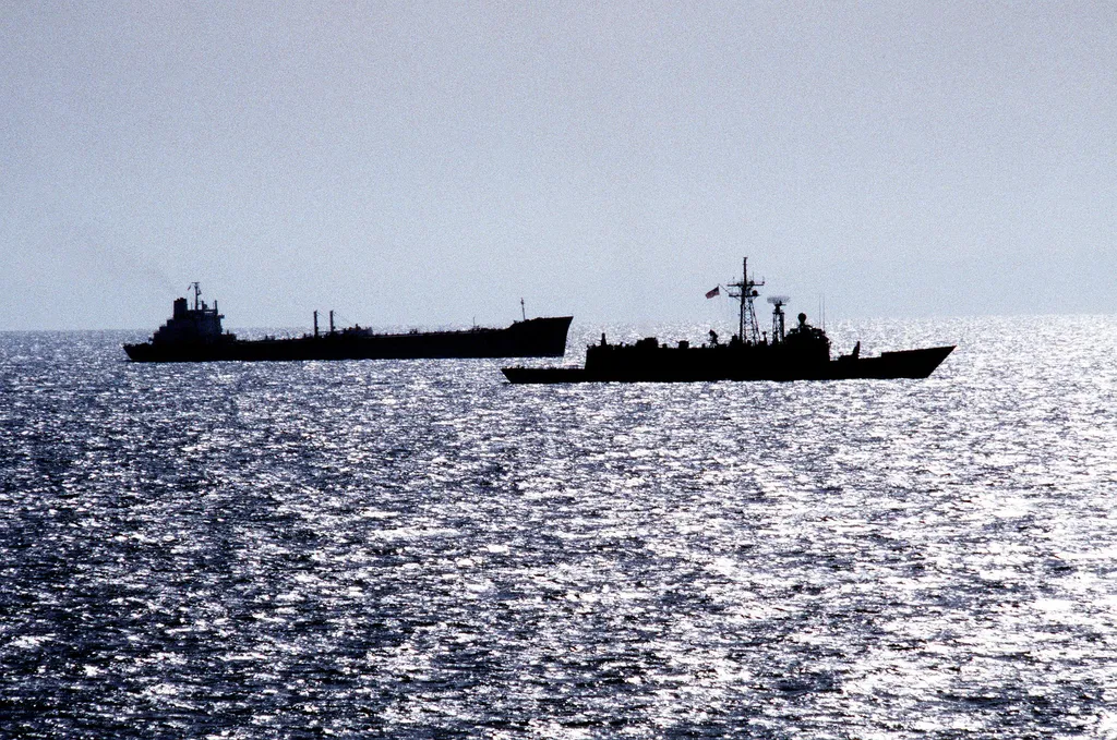 An oil tanker escorted by a warship in the Strait of Hormuz (US Navy archival photo, 1987).