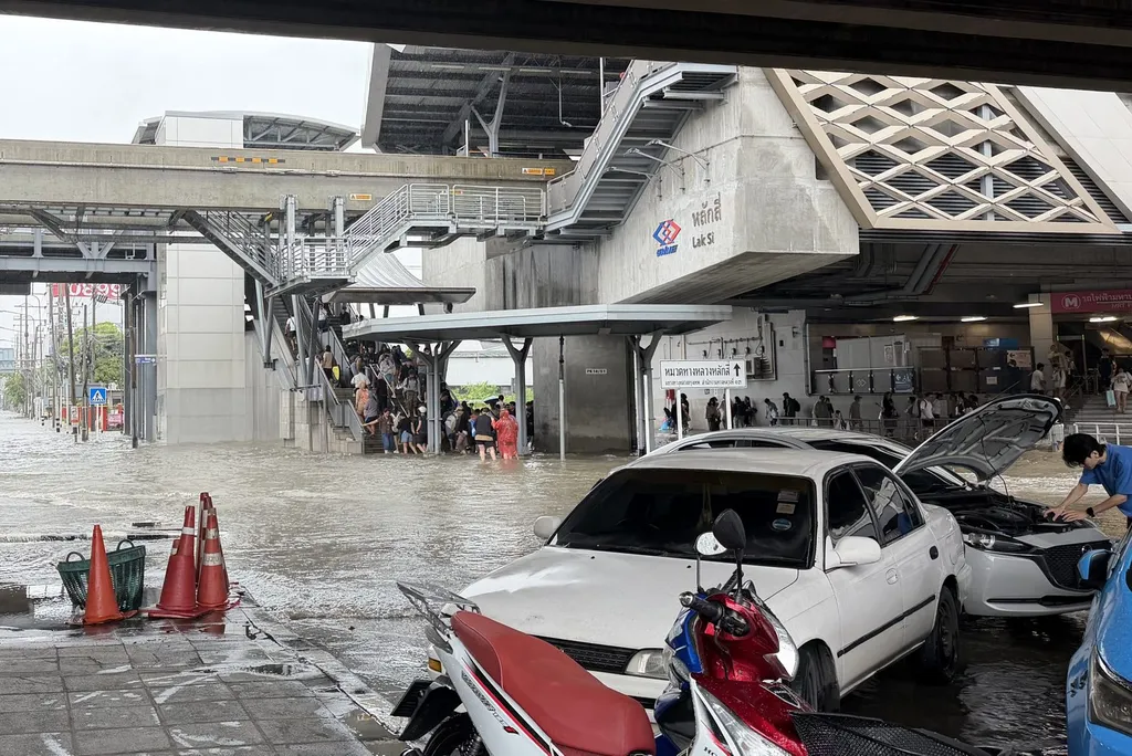 Commuters wading through floodwater at Bangkok's Lak Si transport hub during the September 2026 floods.