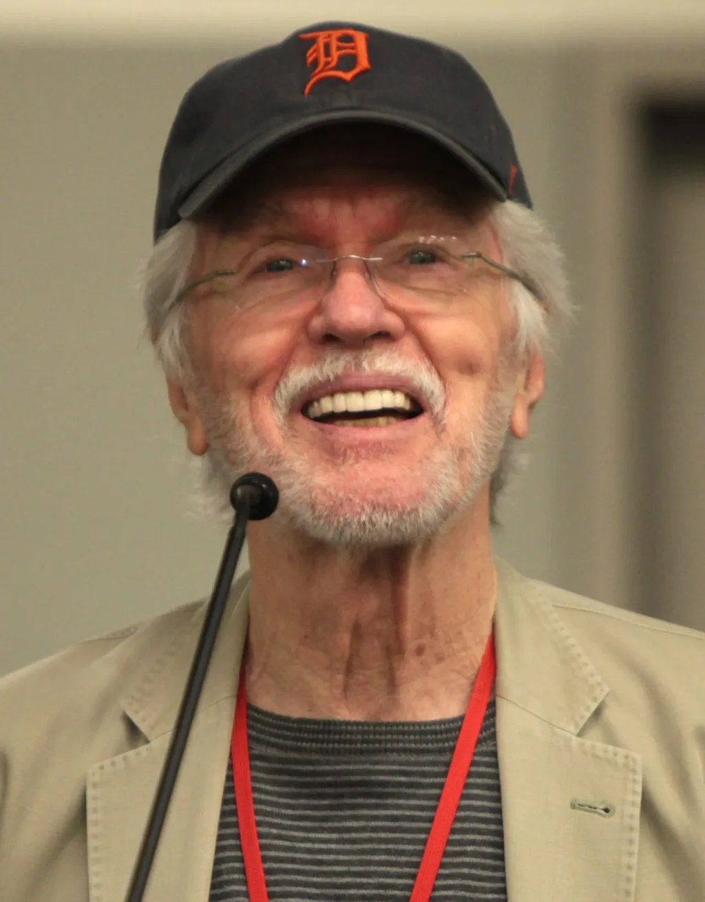 Tom Skerritt, smiling in glasses and a Detroit baseball cap, photographed at a 2014 Phoenix Comicon fan panel