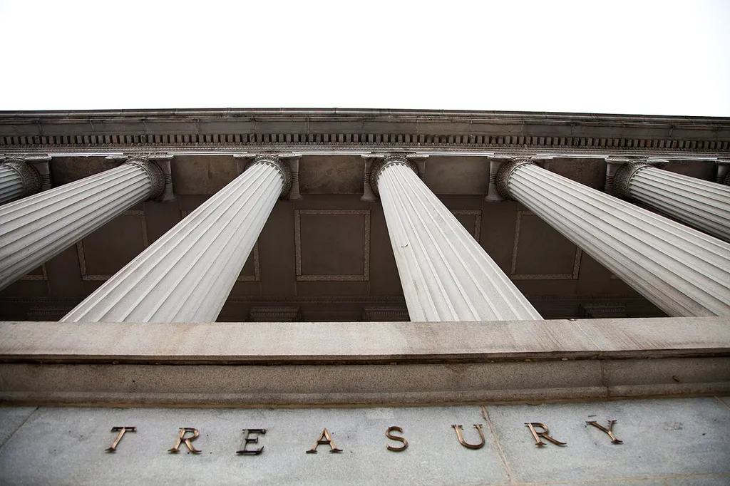 The colonnaded facade of the US Treasury Building in Washington, DC, with the word TREASURY carved into the stone.