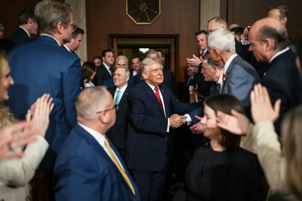 US President Donald Trump shakes hands with lawmakers as he arrives on the House floor to deliver his 2026 State of the Union address