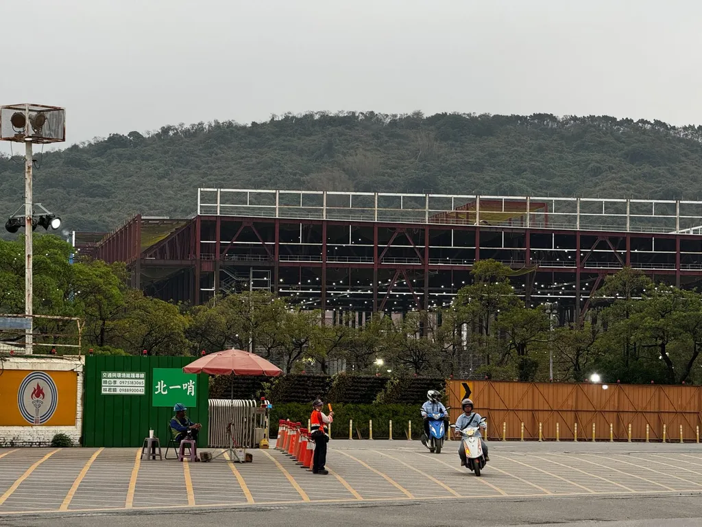 Steel-structure framework of TSMC Fab 22 under construction in Kaohsiung’s Nanzih District, April 2024, seen from the site entrance.