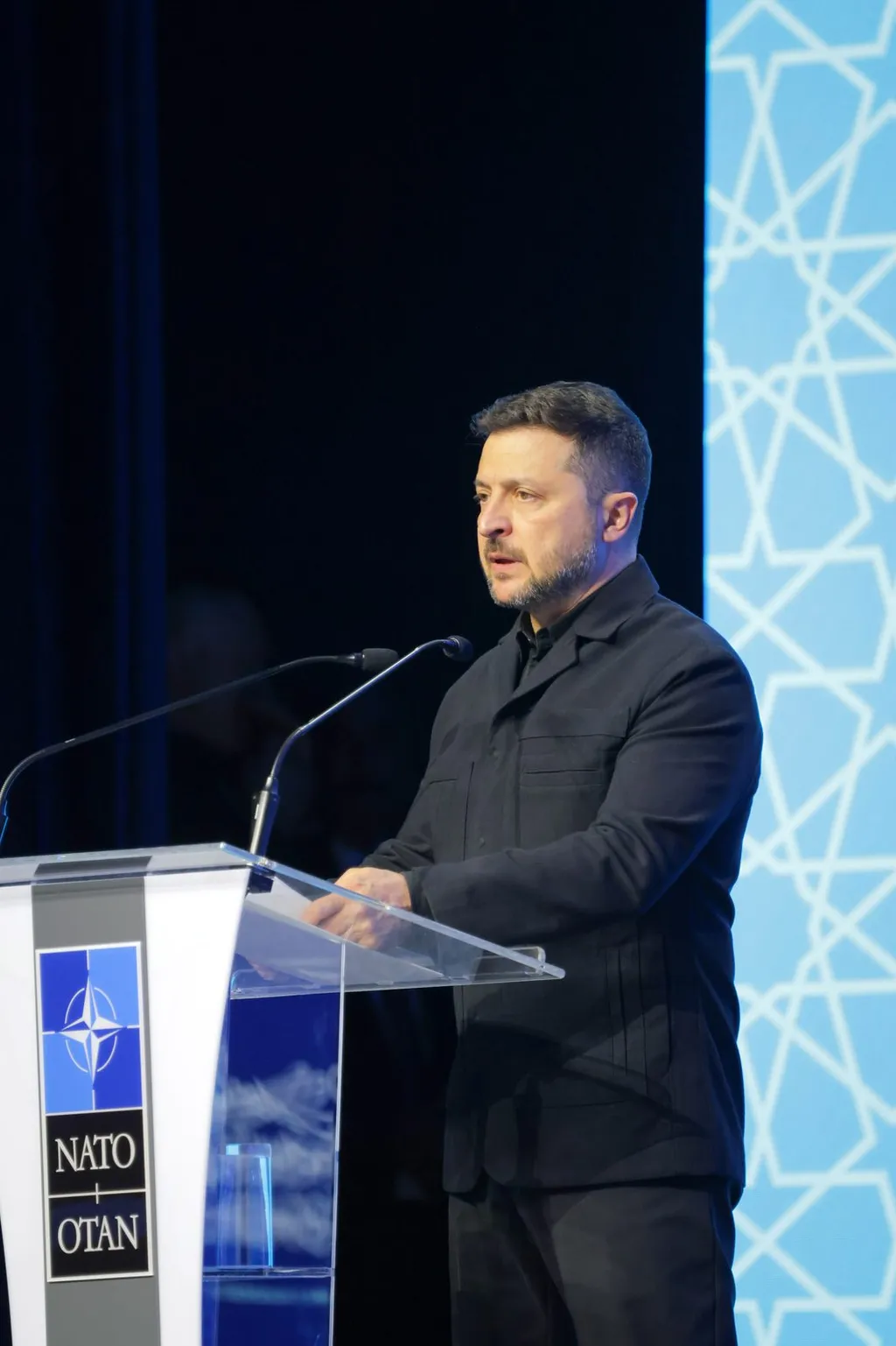 Volodymyr Zelenskyy speaking at a NATO lectern during the 2026 NATO summit in Ankara, Türkiye